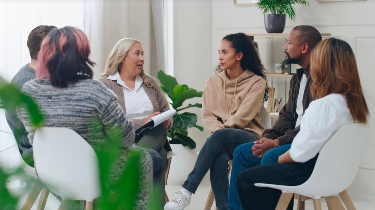 Illustrative photo of adults having a seated group conversation